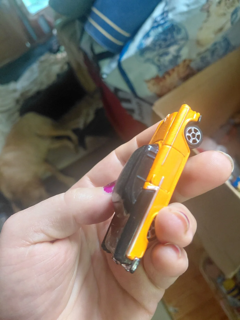 Maisto 1955 Chevrolet Bel Air 1:64 scale diecast car in orange and black.